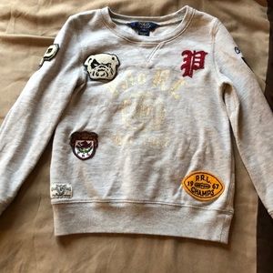 Crew neck sweater with patches on it.